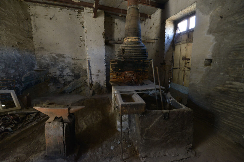 Η βούτα, το αμώνι και η καμινάδα του εργαστηρίου του μπαρμπα Κώστα, 20 χρόνια μετά το κλείσιμο. Χαρακτηριστικό Τηνιακό δείγμα είναι το κιούπι από πηλό που είναι πυρήμαχος.